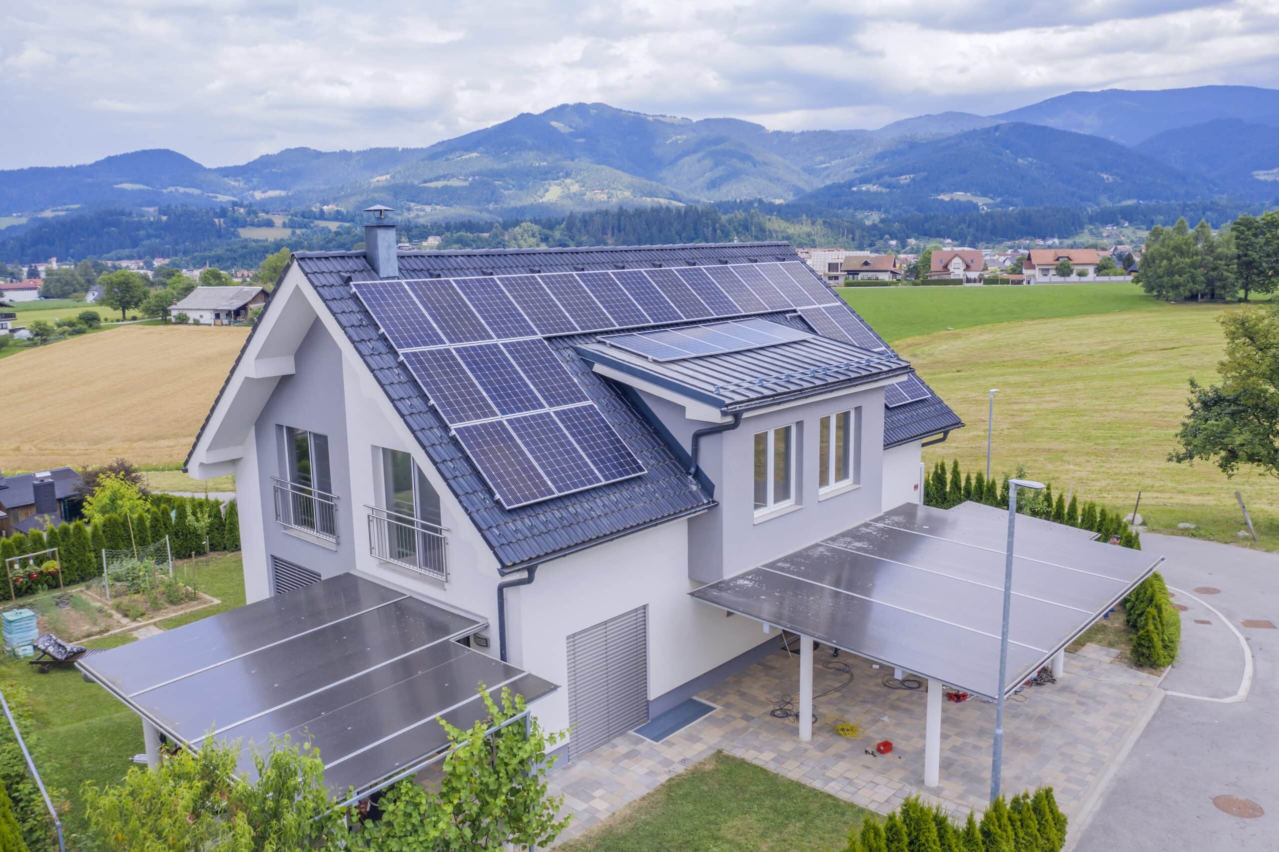 high angle shot of a private house situated in a valley with solar panels on the roof